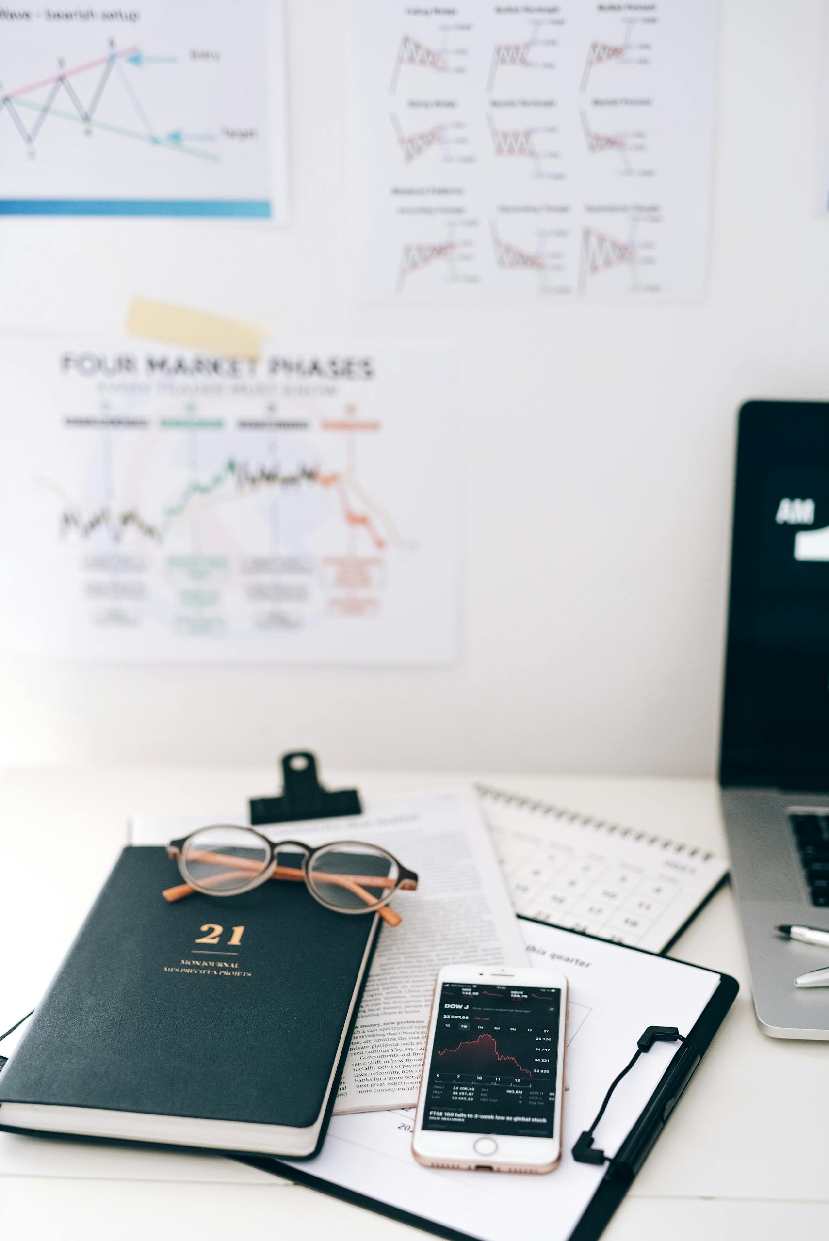A workspace with smartphone and financial graphs, ideal for business concepts.